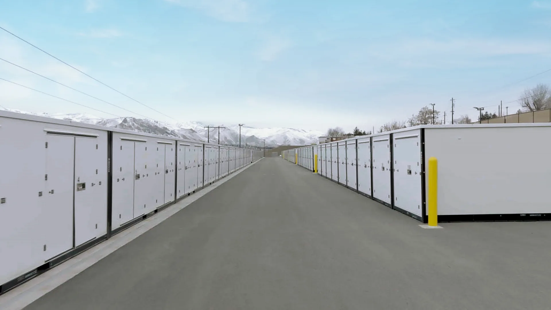 Storage facility with white containers lining a paved driveway