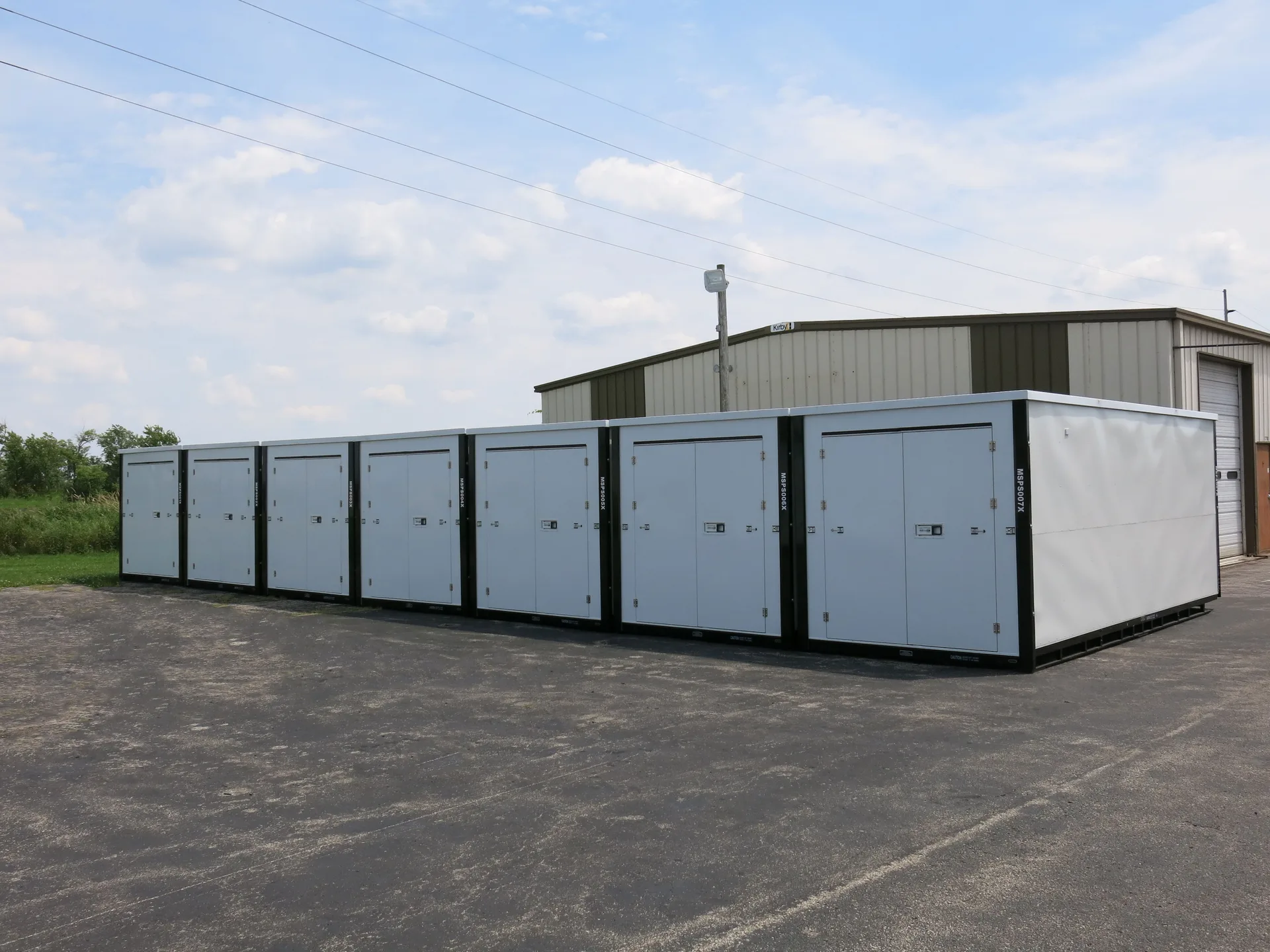 White storage containers arranged beside a building