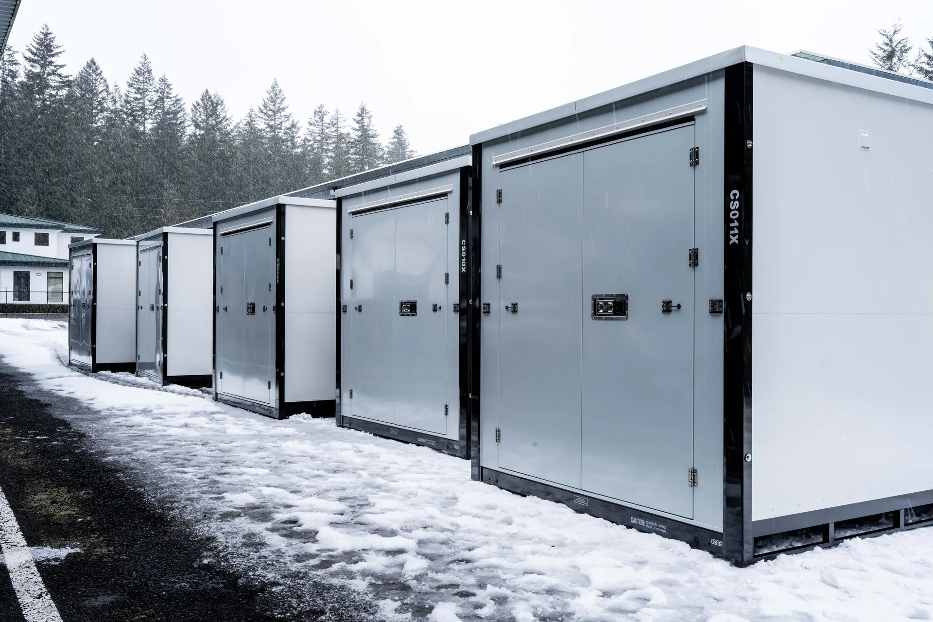 White storage containers at a snow-covered facility